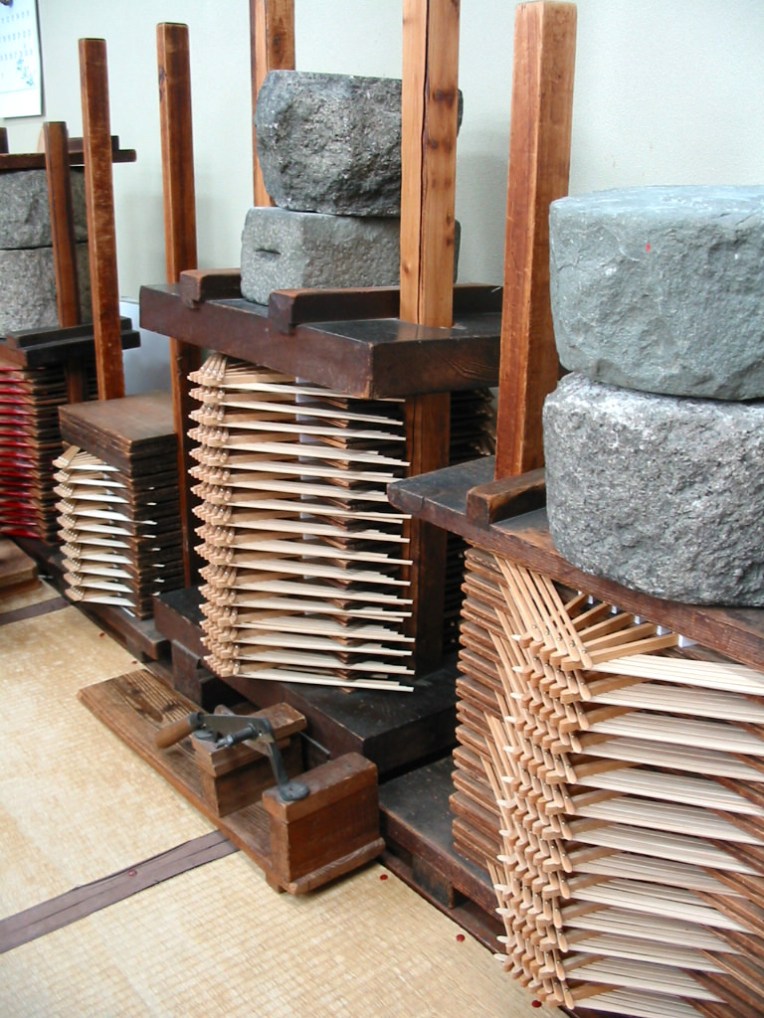 のり付けされた扇子に重しをしている様子